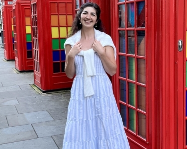 Nicole Sauter stands in front of telephone booths decorated in rainbow colors